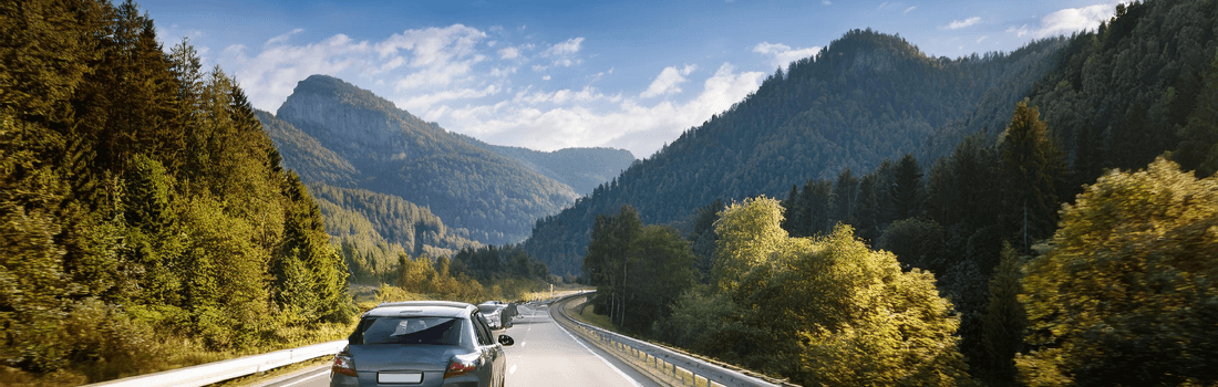 Scenic German road with a luxury car driving on the autobahn, surrounded by mountains